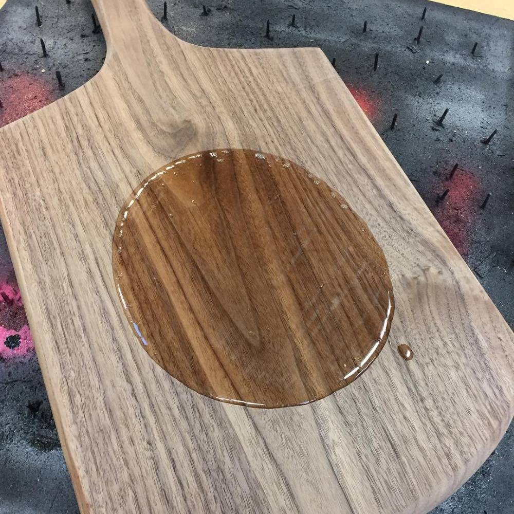 Wooden cutting board with a freshly applied circle of mineral oil for seasoning and protecting wood surfaces