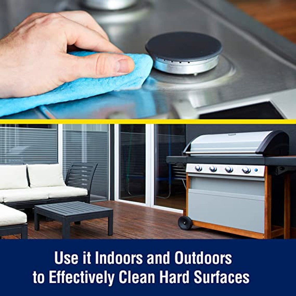 Hand wiping stainless steel stove burner top with blue cloth in indoor kitchen setting