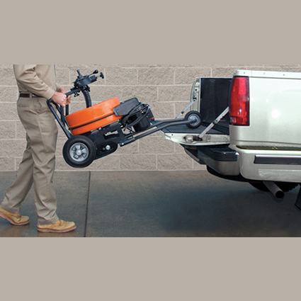Person wheeling a heavy-duty orange and black plumbing tool with cable reel onto a pickup truck bed, part of rental equipment for home improvement at Hartville Hardware.