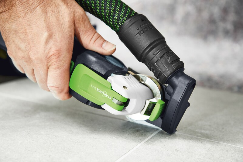 Hand gripping oscillating tool fitted with diamond saw blade cutting tile grout for home improvement task