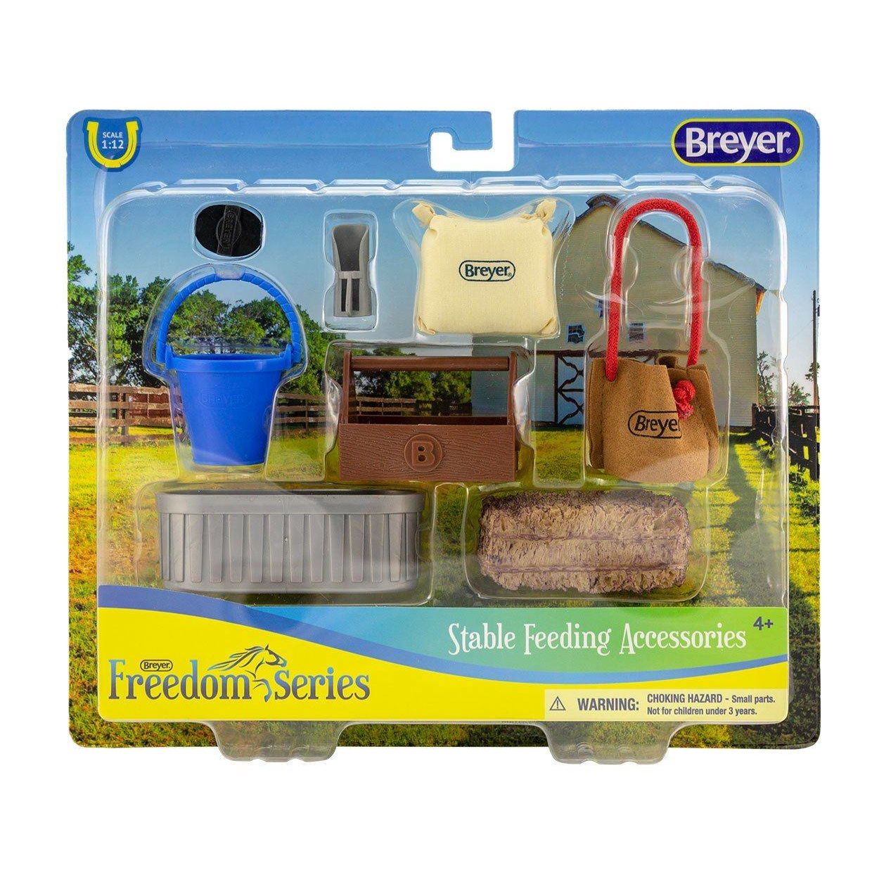 Set of miniature stable feeding accessories including bucket, hay bale, feed tub, and tote bag in clear plastic packaging