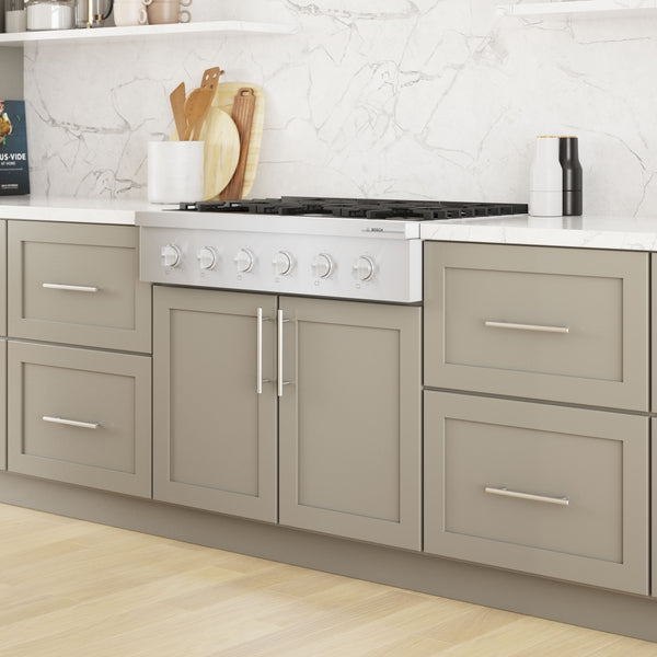36-inch white gas rangetop with six knobs and continuous grates installed in taupe kitchen cabinetry setting