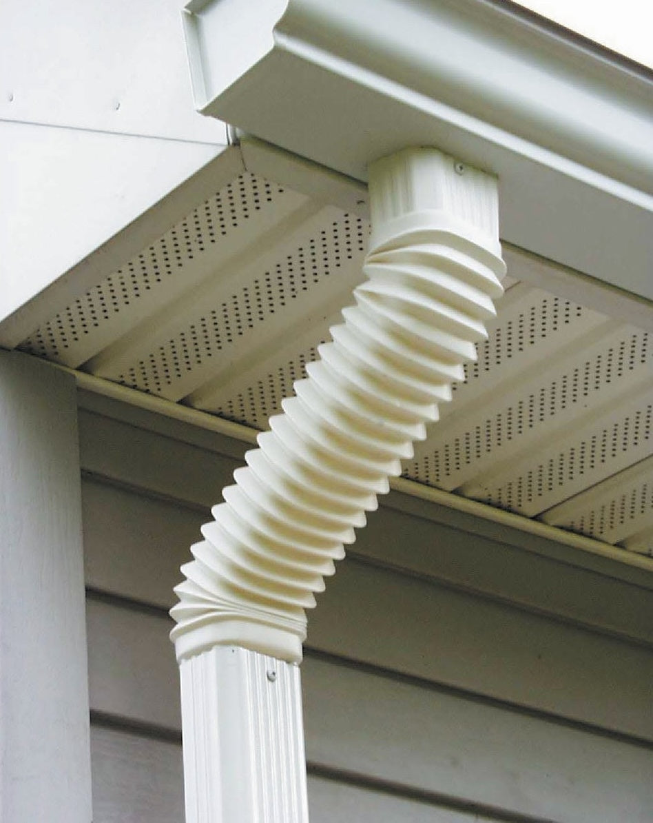 White flexible plastic elbow connecting gutter to vertical downspout for home exterior water drainage and improvement