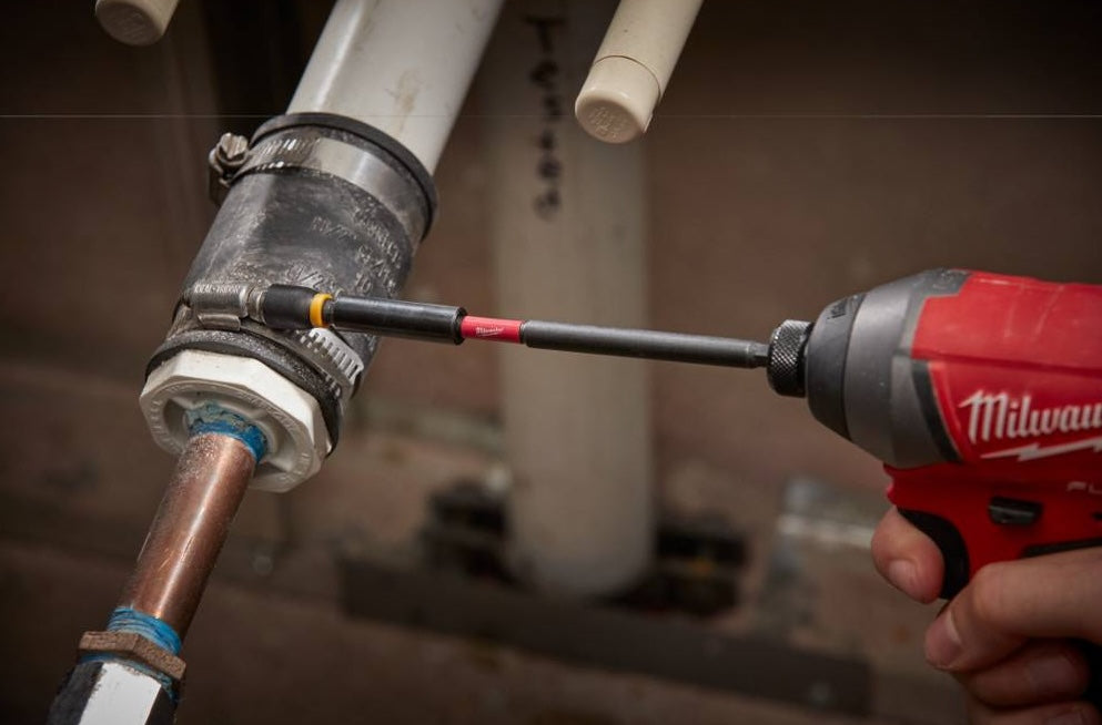 Red and black Milwaukee drill with magnetic bit holder tightening pipe fitting in plumbing tool accessories setting