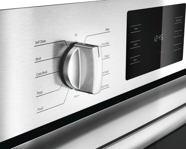 Close-up of stainless steel oven control knob with cooking mode labels and digital touchscreen panel from Bosch wall ovens collection