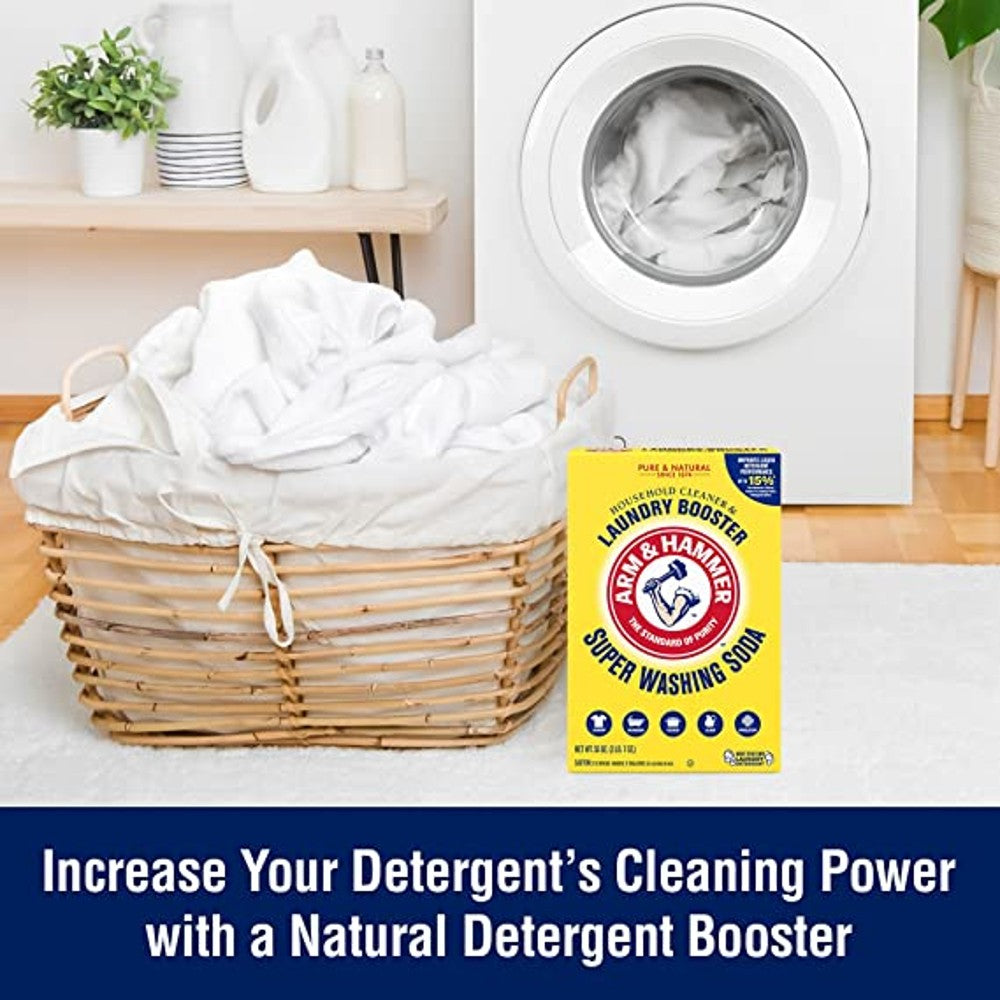Yellow box of Arm & Hammer laundry booster next to a full wicker basket by a white front-load washing machine
