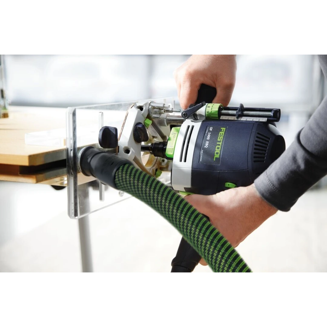 Hands using a Festool router with a clear Plexiglas routing template for precise woodworking tasks