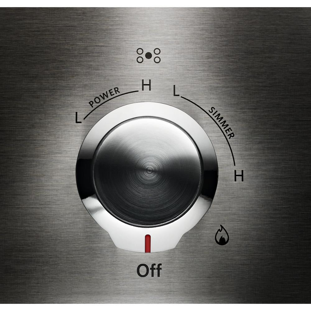 Close-up of stainless steel control knob with power and simmer settings on a gas cooktop appliance panel