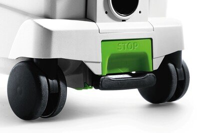 Close-up of black caster wheels and green stop lever on Festool dust extractor for woodworking tools and air filtration.