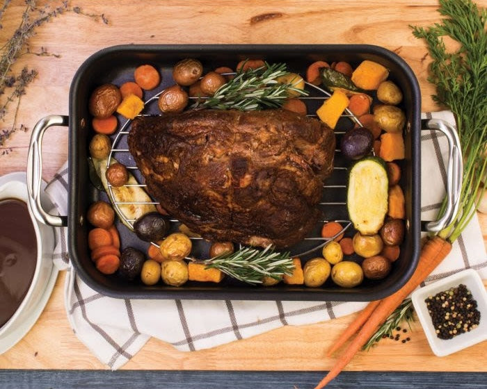 Chrome-plated oval wire rack in roasting pan with cooked meat and assorted vegetables for kitchenware collections under $50