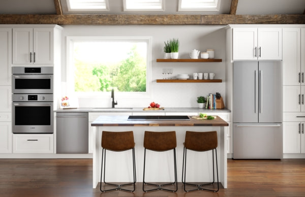 Modern kitchen featuring stainless steel combination built-in oven, refrigerator, and white cabinetry from Bosch Appliances collection