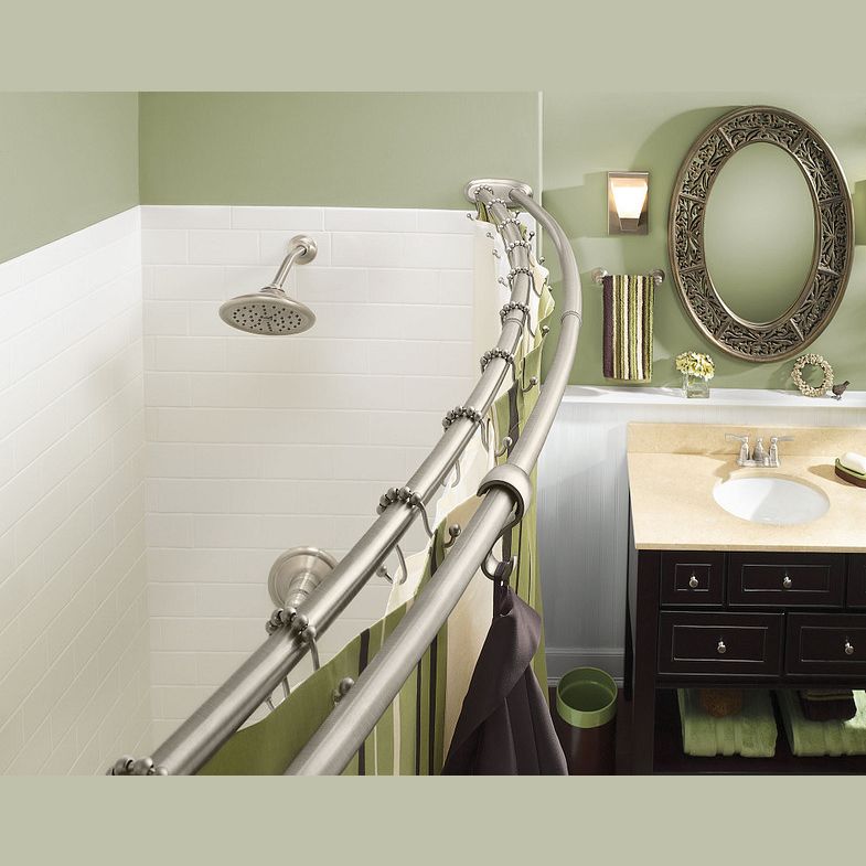 Curved brushed nickel shower rod installed in bathroom with white tile shower and green painted walls