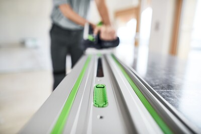 Close-up of aluminum guide rail with green accents used in woodworking tool accessories for precise cutting and home improvement.