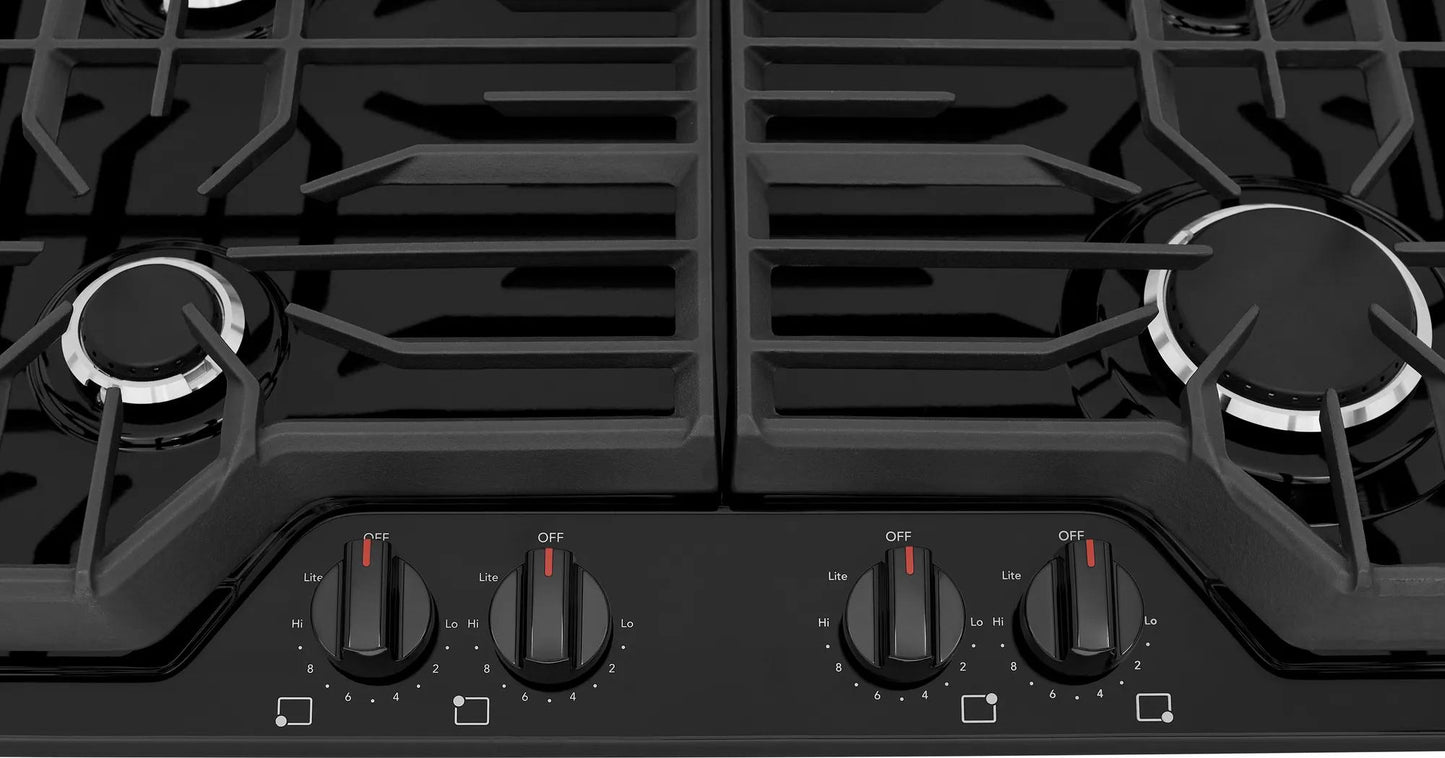 Close-up of black gas cooktop with four front control knobs and continuous edge-to-edge grates for kitchen appliances collection