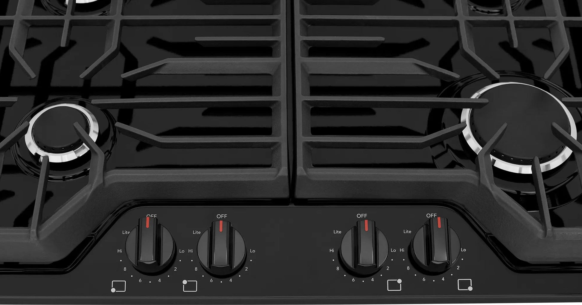 Close-up of black gas cooktop with four front control knobs and continuous edge-to-edge grates for kitchen appliances collection