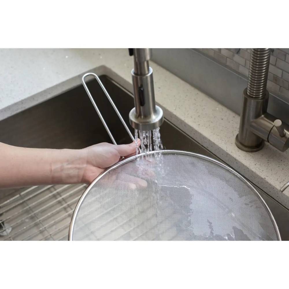 Hand washing stainless steel splatter screen with wire handle over kitchen sink in kitchenware and Lodge collections