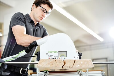 Man wearing safety glasses operating Festool plungecut saw with 75-inch guide rail for precise woodworking in power tools collection
