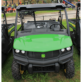 Green John Deere crossover utility vehicle with spacious cab and rugged tires for versatile outdoor and home improvement use