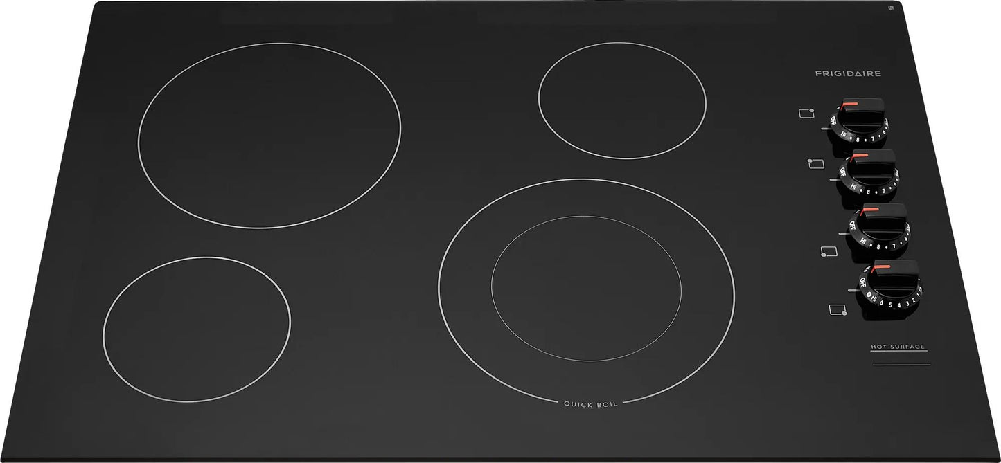 Black frameless electric cooktop with four electric burners and rotary temperature controls in kitchen appliance collection