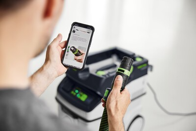 Person scanning barcode on Festool accessory near dust extractor for woodworking tools and dust collection
