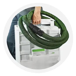 Person holding a white modular storage box with a coiled green hose draped over the handle, suggesting organization for tools or accessories.