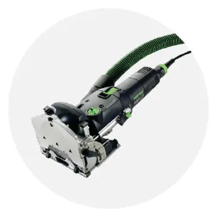 Electric woodworking joiner with a black and green body and attached dust extraction hose designed for precise home improvement tasks.