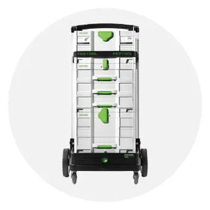 Tall modular storage system with stacked gray compartments, green handles, and large wheels for easy transport in home improvement settings.