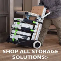 Person using a wheeled organizer cart loaded with stacked tool storage boxes beside a building entrance, demonstrating portable storage solutions.
