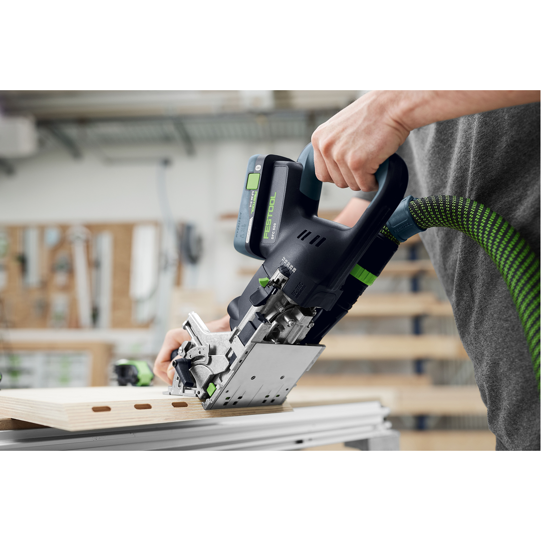 Person using a Festool power tool to create precise mortise joints in light wood, demonstrating accuracy in woodworking and home improvement projects.