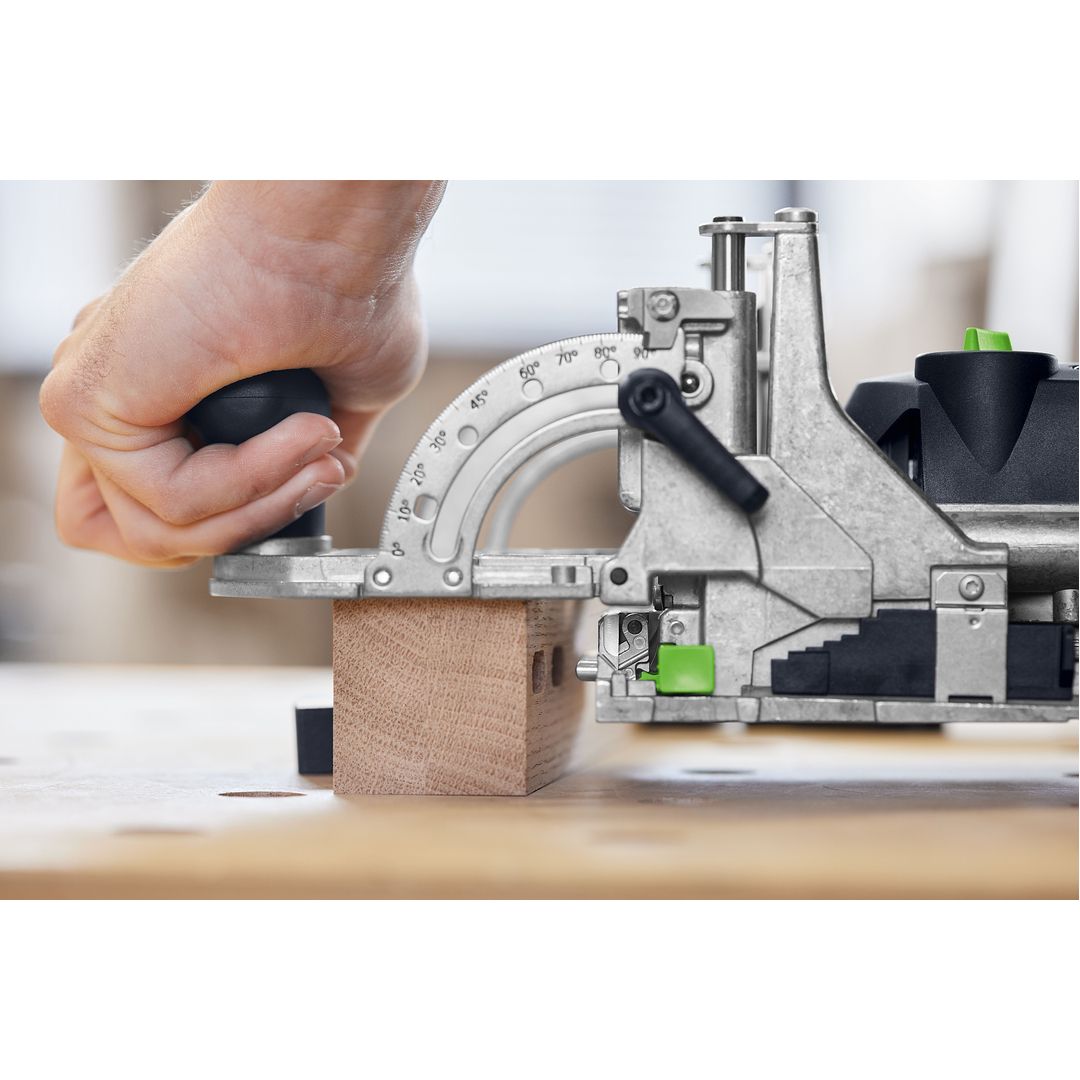 Close-up of a hand operating a precision joiner tool to make angled cuts on a wood block in a woodworking workshop, part of power and woodworking tools collections.