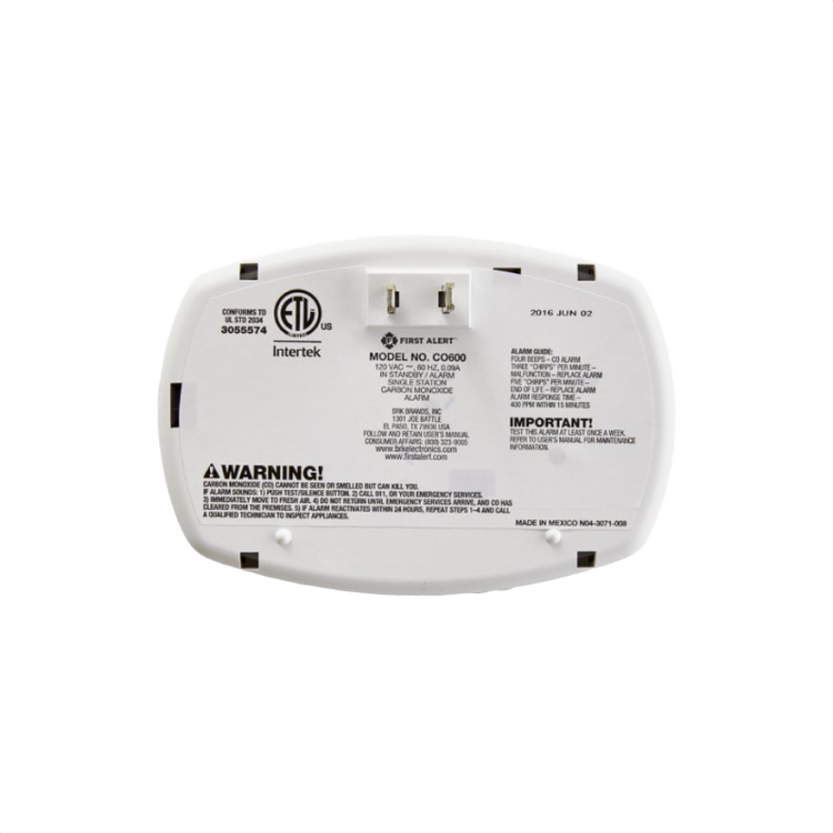 Back view of white First Alert CO600 120V plug-in carbon monoxide alarm with labels and safety warnings for home use