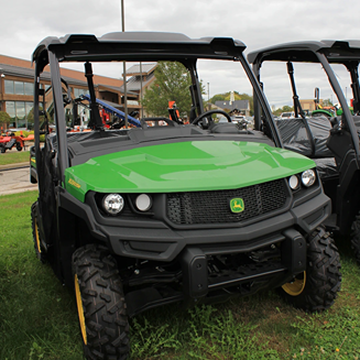 Green John Deere utility vehicle with raised cargo bed and durable tires for outdoor and home improvement use