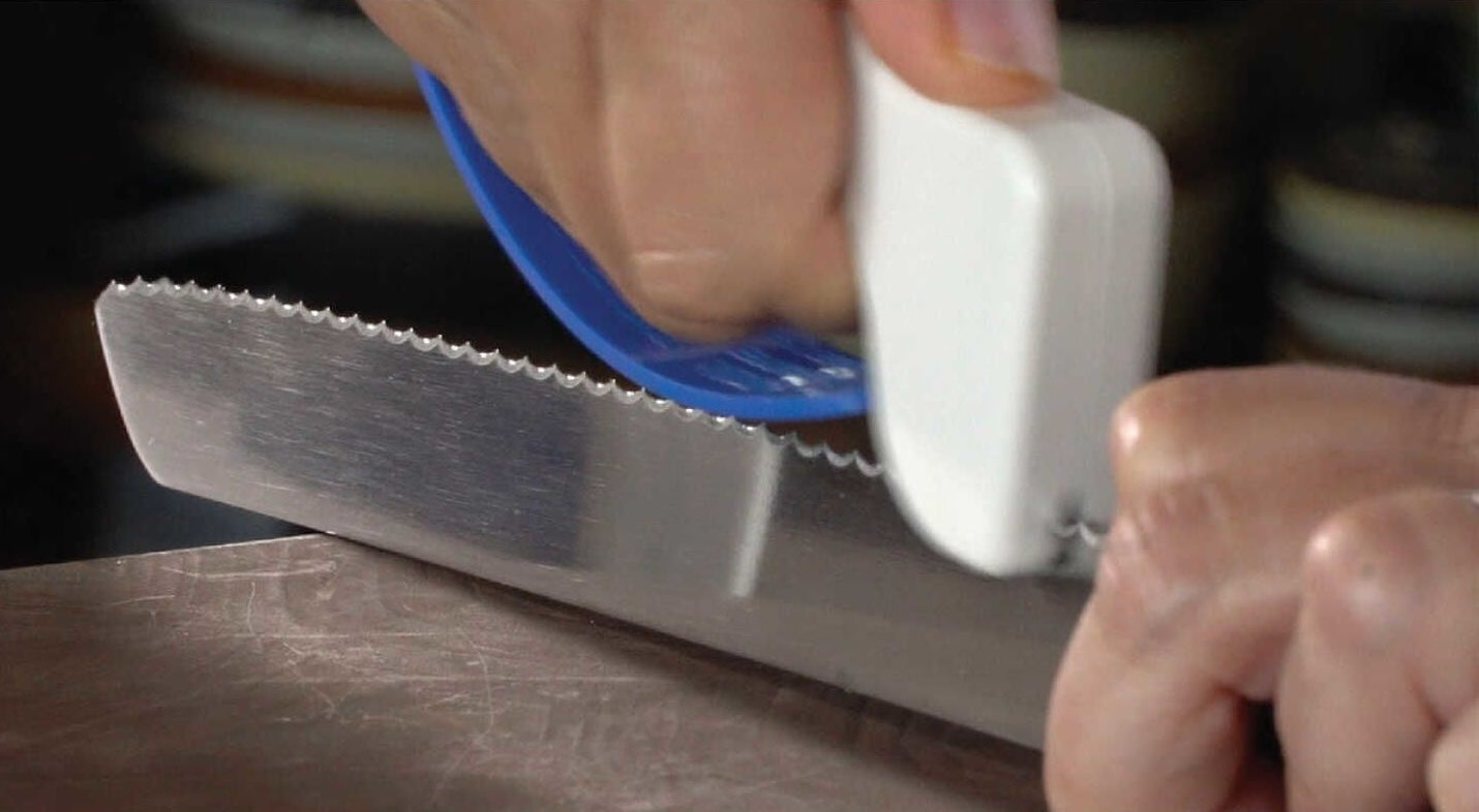 Handheld sharpener restoring edge on a serrated kitchen knife, suitable for woodworking tool accessories under $50
