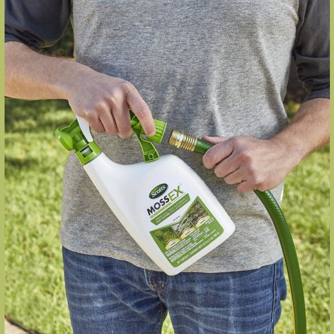 Person attaching Scotts MossEX 3-in-1 spray bottle to garden hose for lawn care and home improvement use