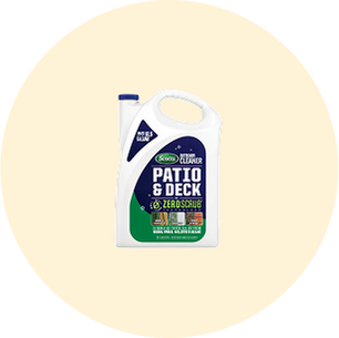 White plastic container with a green label for a cleaning solution designed for patios and decks, featuring a handle and blue cap.